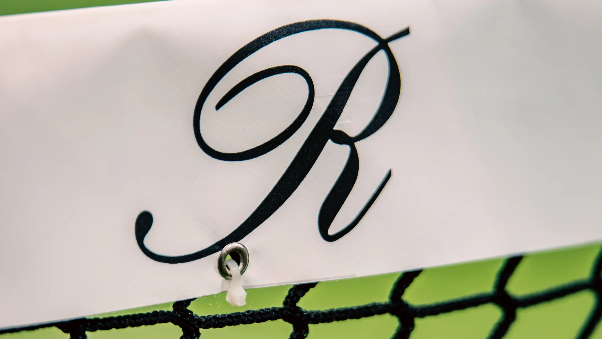 The Reserve R on the white band of the net