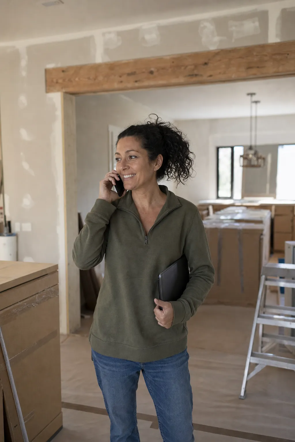 A remodeling project manager on the phone in a kitchen mid-remodel
